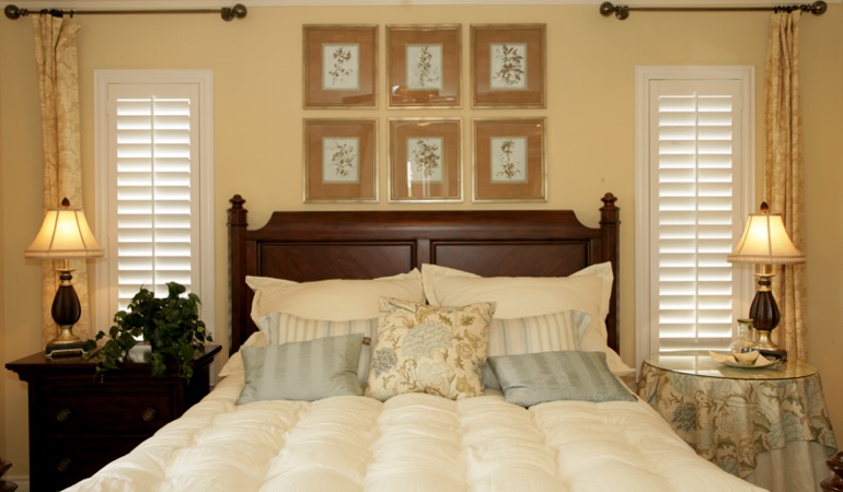 Beige bedroom with white plantation shutters covering windows in Atlanta 